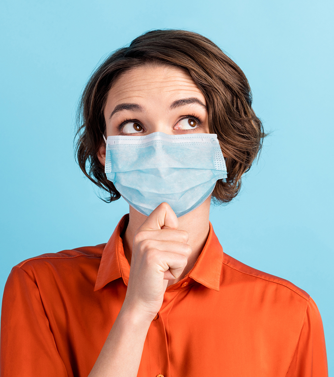 Woman wearing orange shirt and blue mask