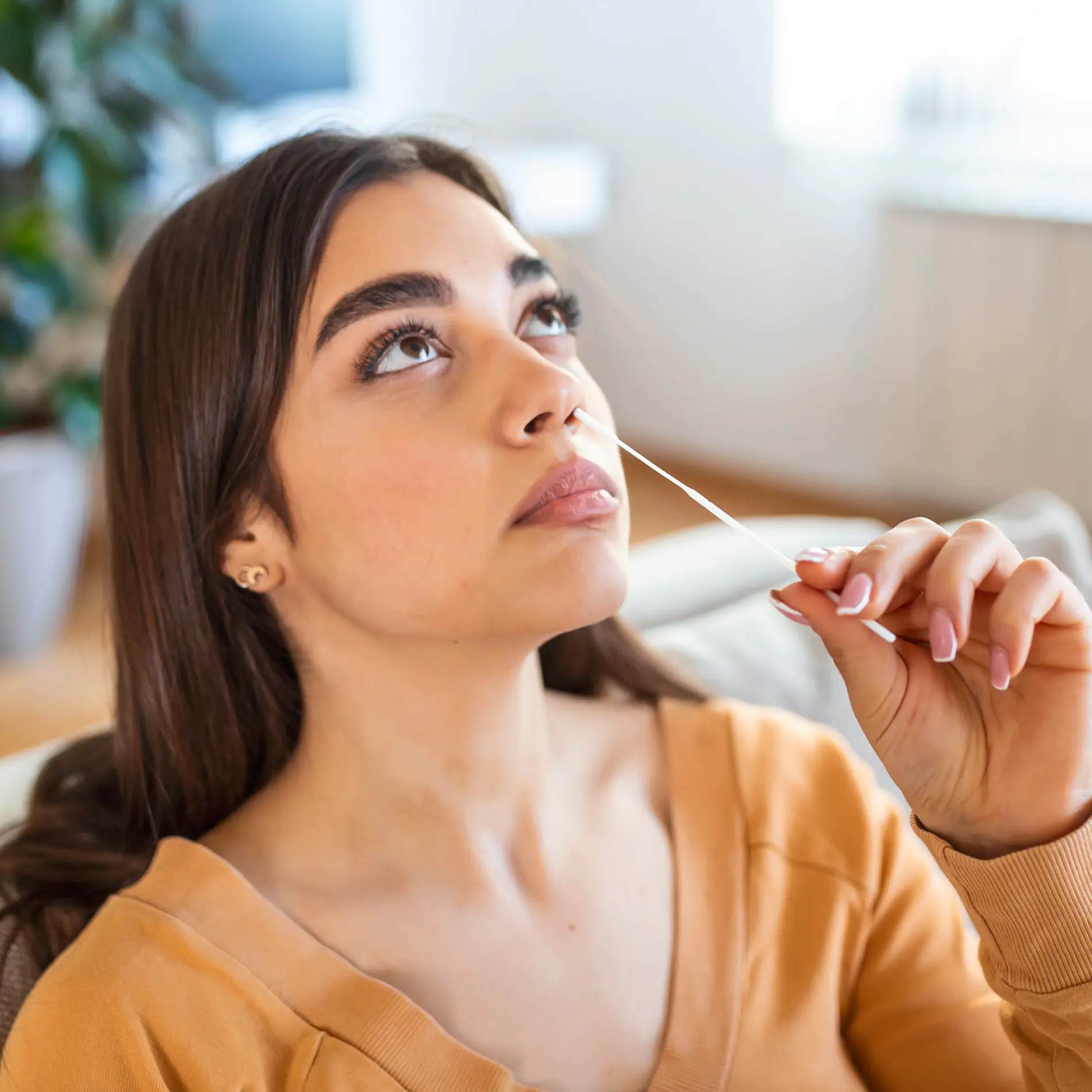 Woman using her My Labs Direct at-home health test kit for covid, flu, and strep tests.