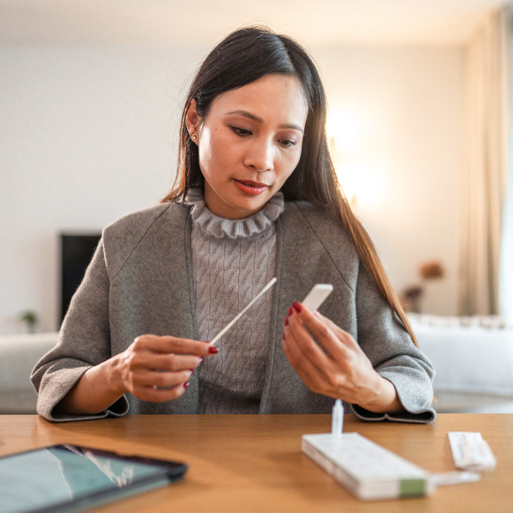 Woman using her My Labs Direct at-home health test kit for covid, flu, and strep tests.